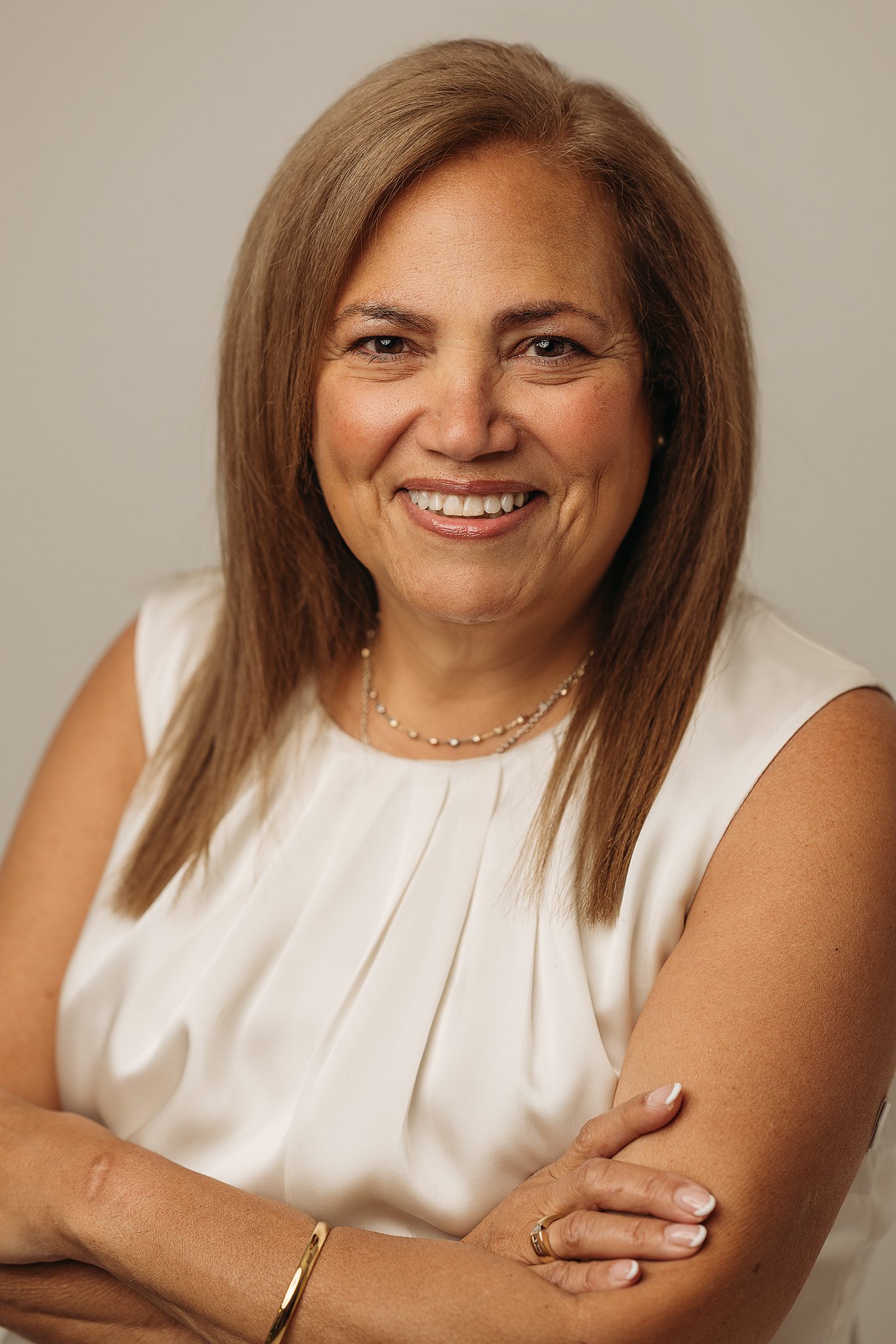 Professional woman headshot infront of simple beige backdrop