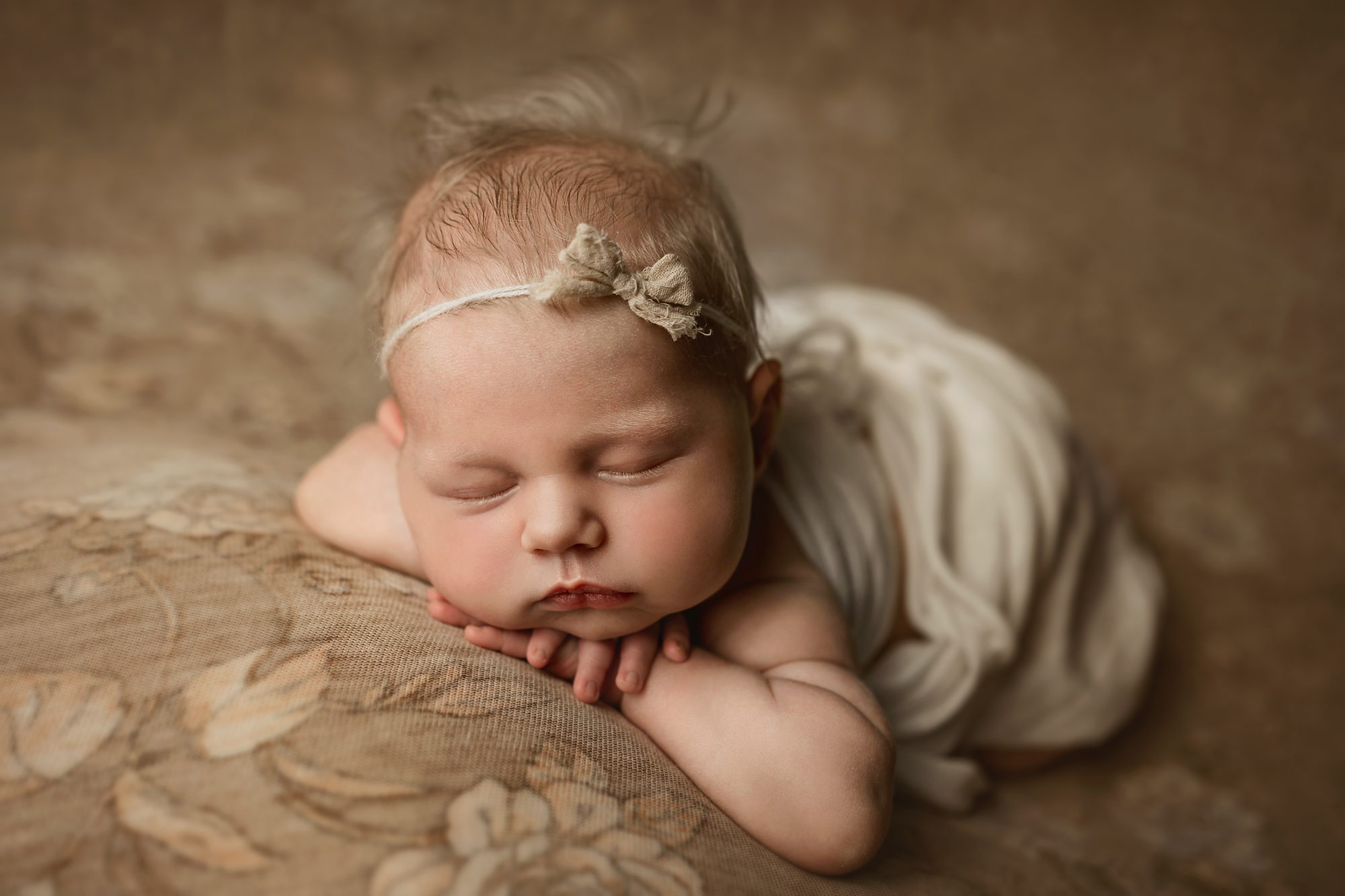 sweet newborn sleeping peacefully on floral backdrop