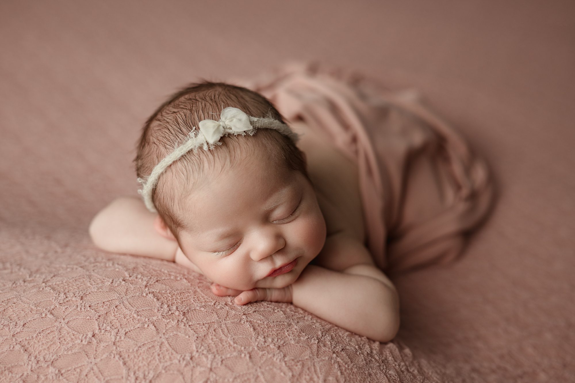 newborn girl on a pink backdrop at photoshoot with joan marie photography in scotch plains nj