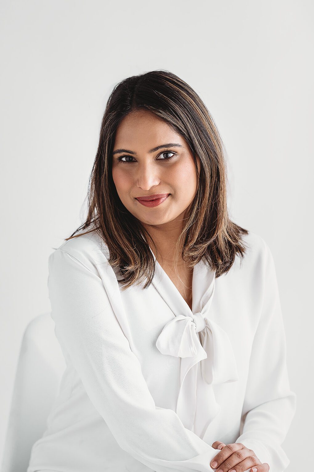 headshot of a woman with brown hair on a white backdrop