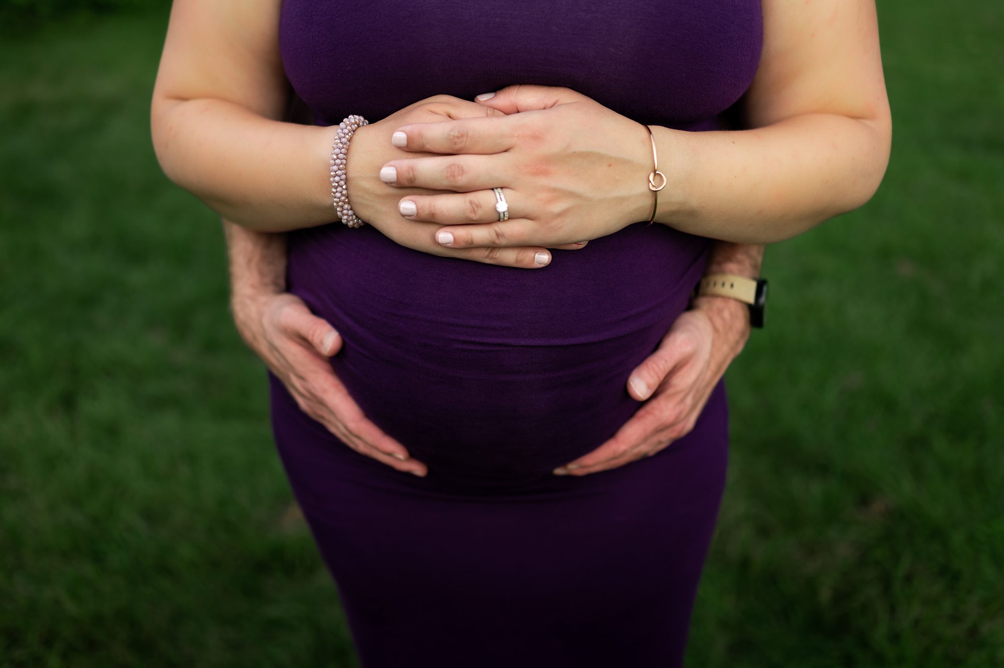 mom and dad's hands on pregnant belly