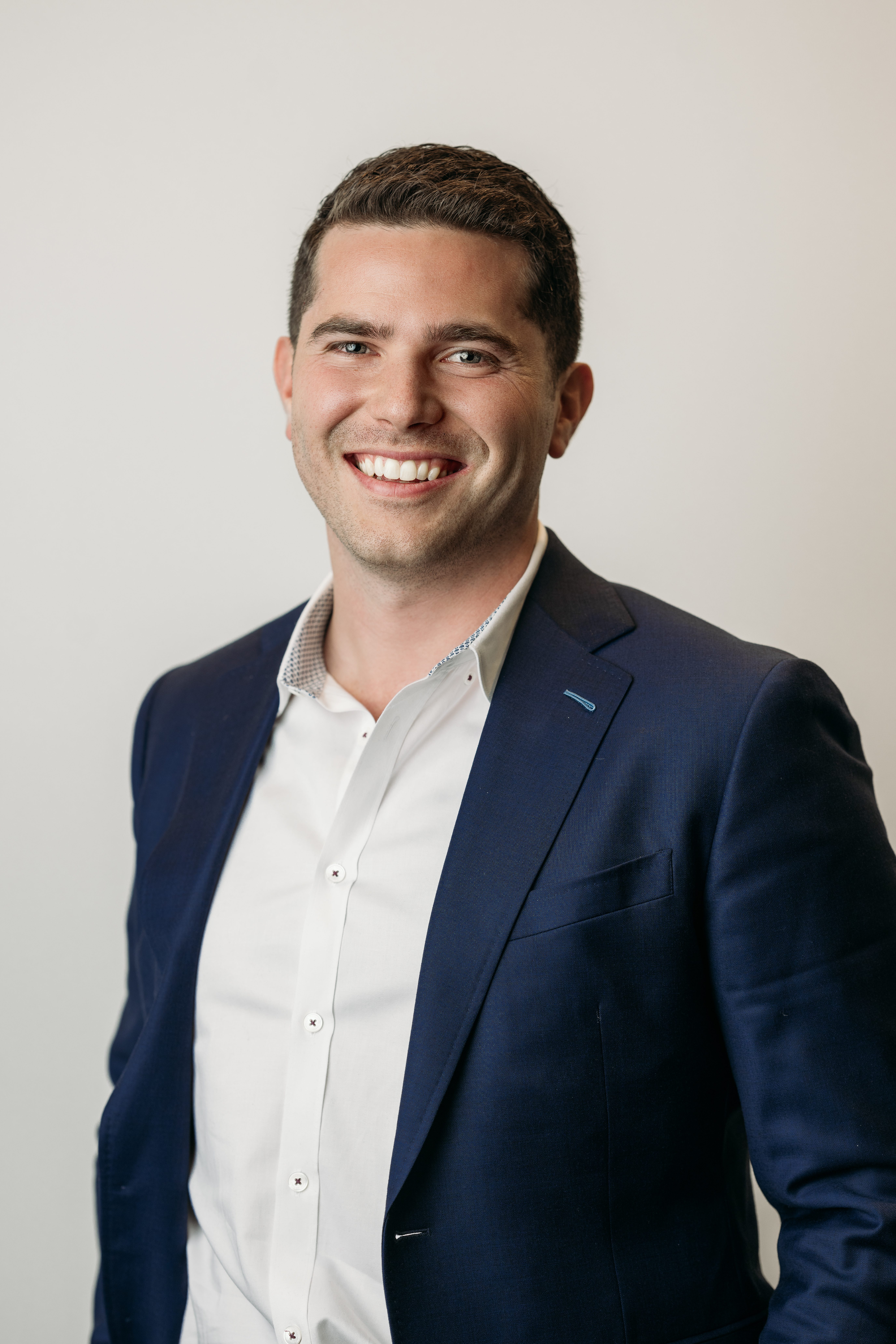 young man in a suit poses for his headshot