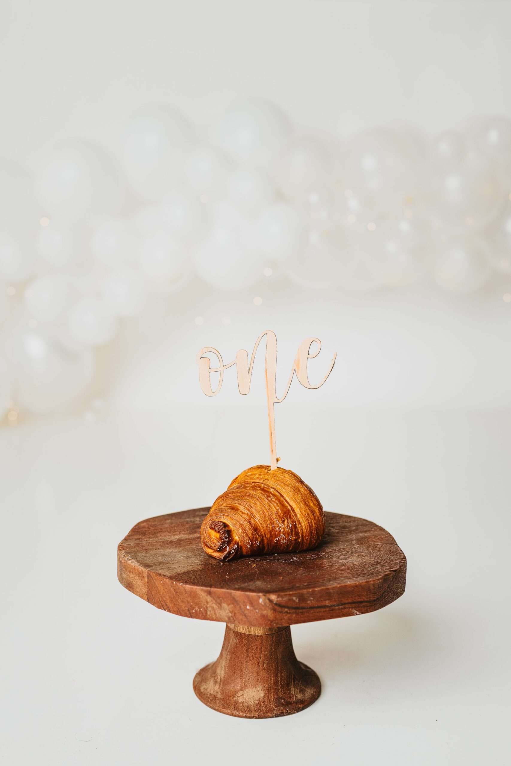 sweet blonde baby celebrates her first birthday with a croissant and a photoshoot at Joan Marie Photography in Scotch Plains NJ