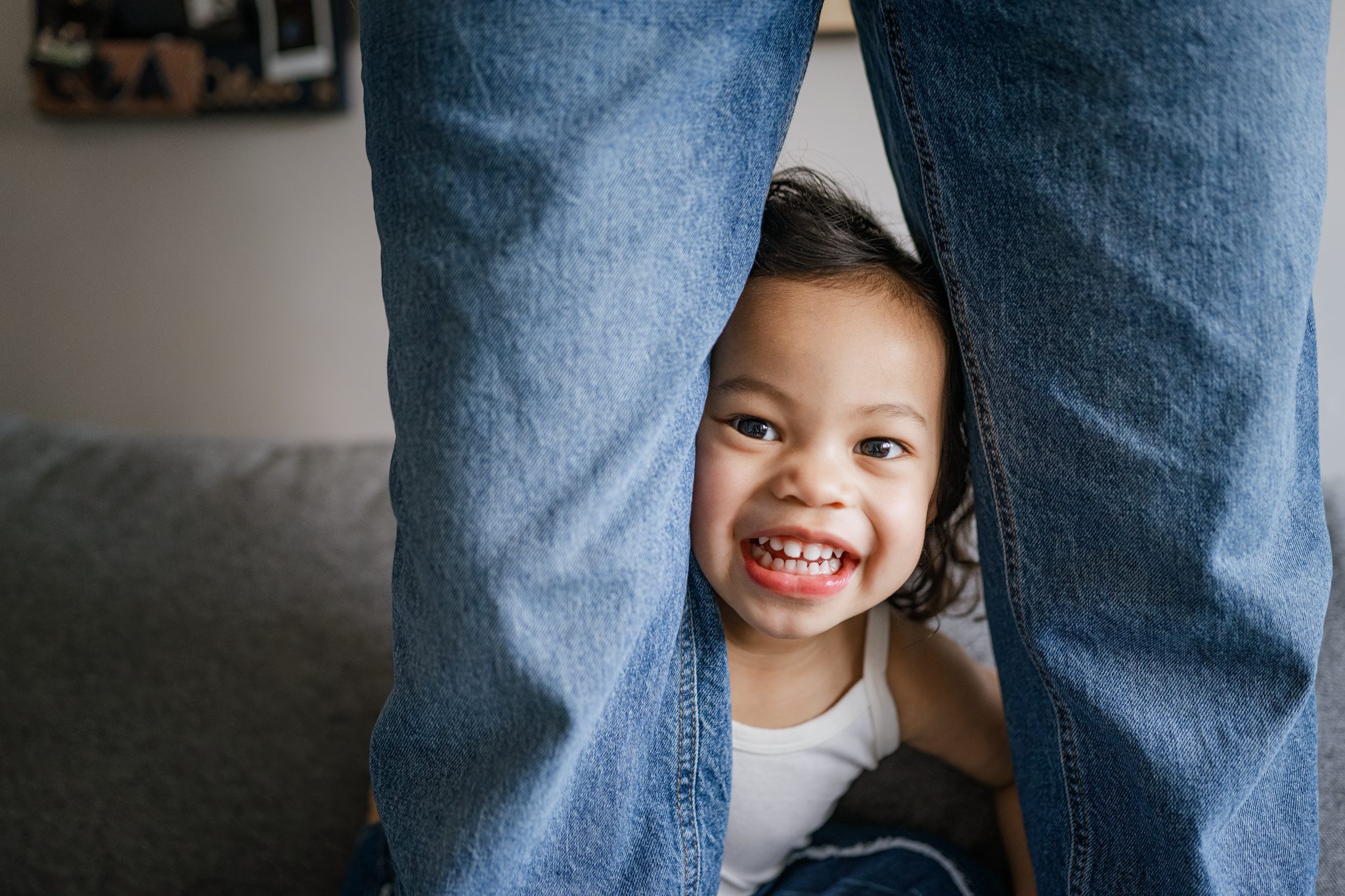 little girl peeks through pregnant momma's jeans