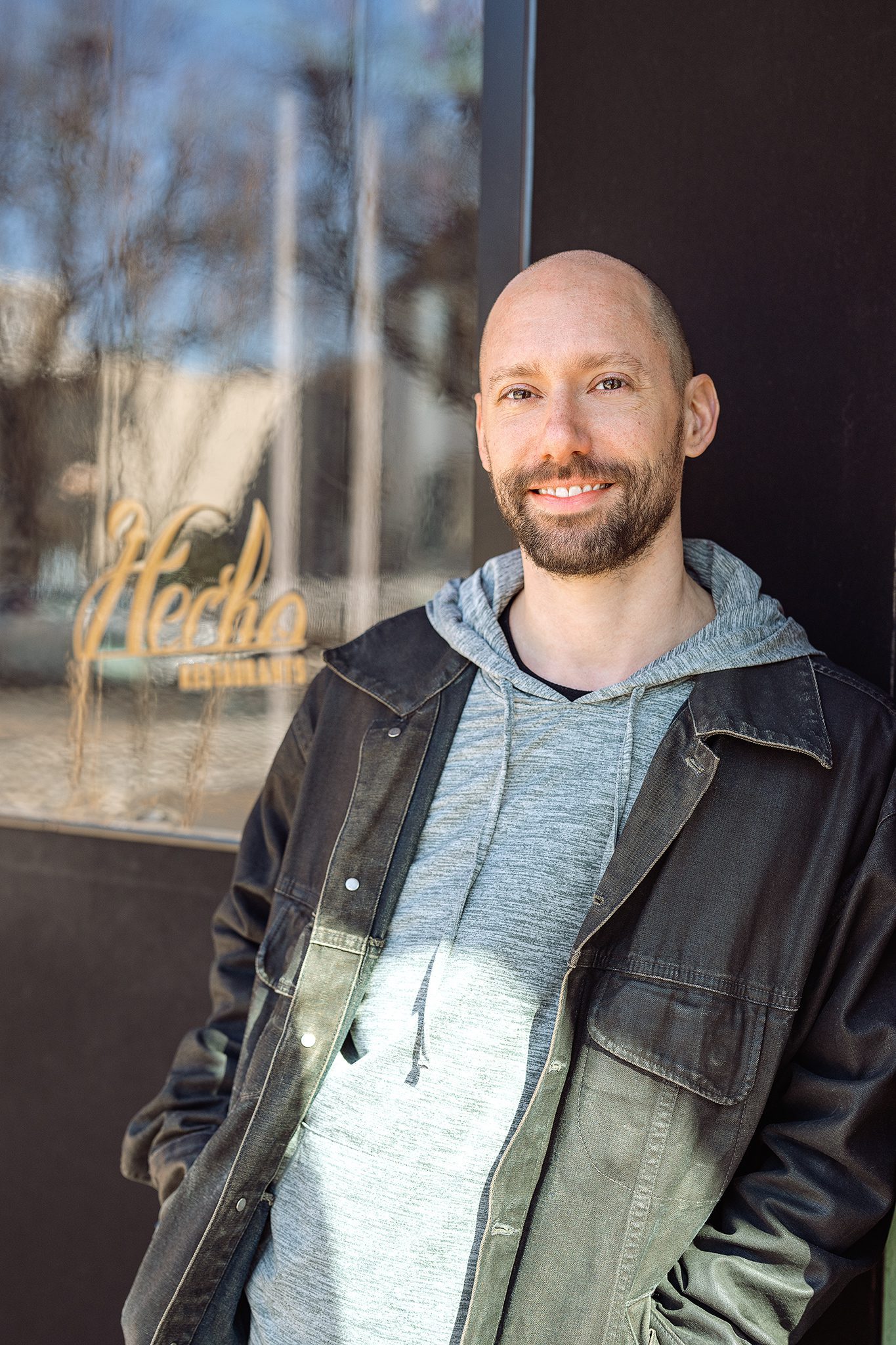 young bald man with facial hair poses for his dating profile session with joan marie photography at lokl and downtown morristown nj