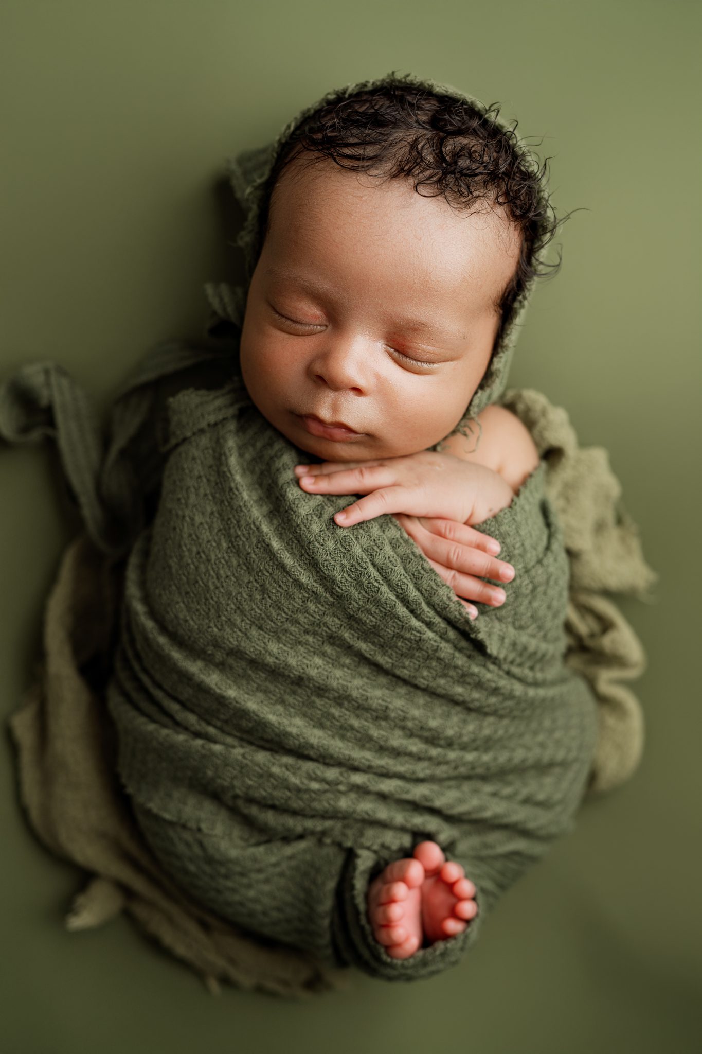newborn photo of baby swaddled in a green wrap