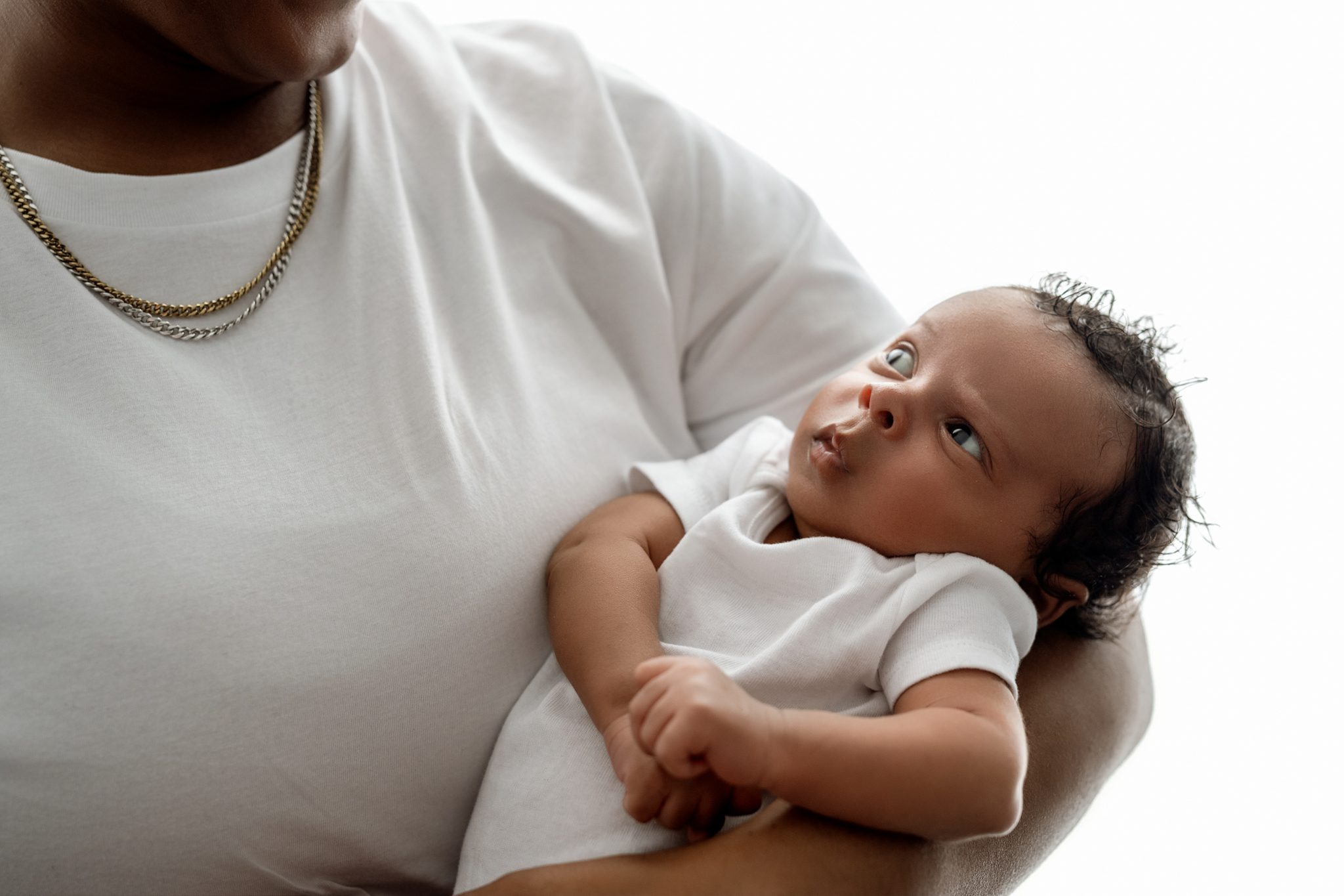mom holding baby boy in a backlit image