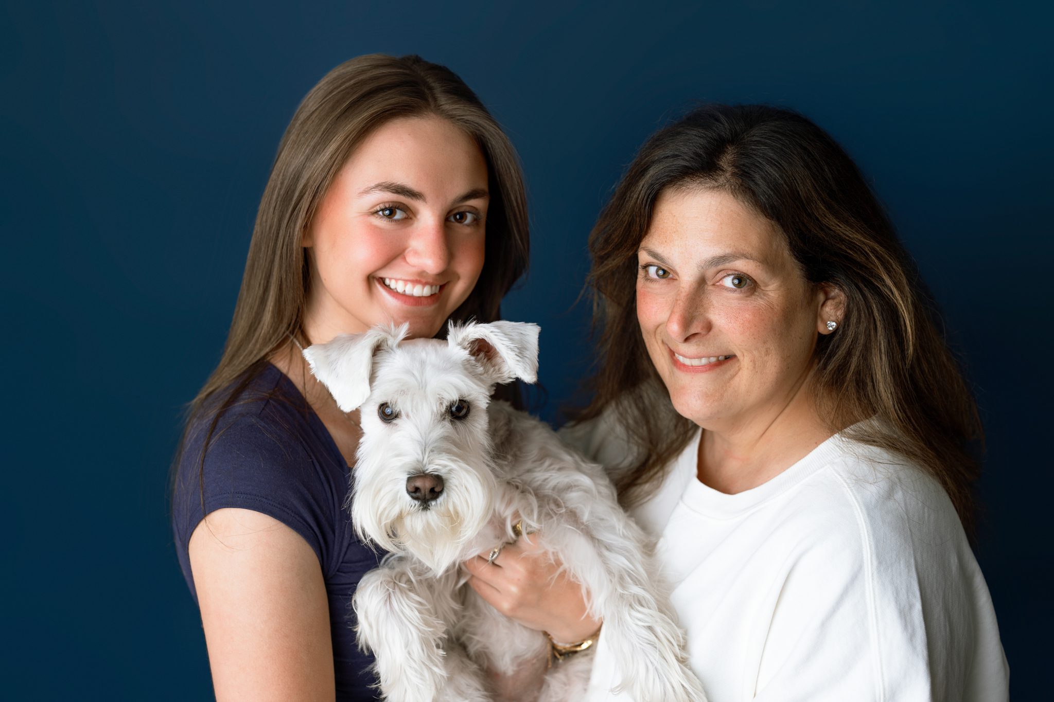 white schnauzer with his mom and teenage human sister