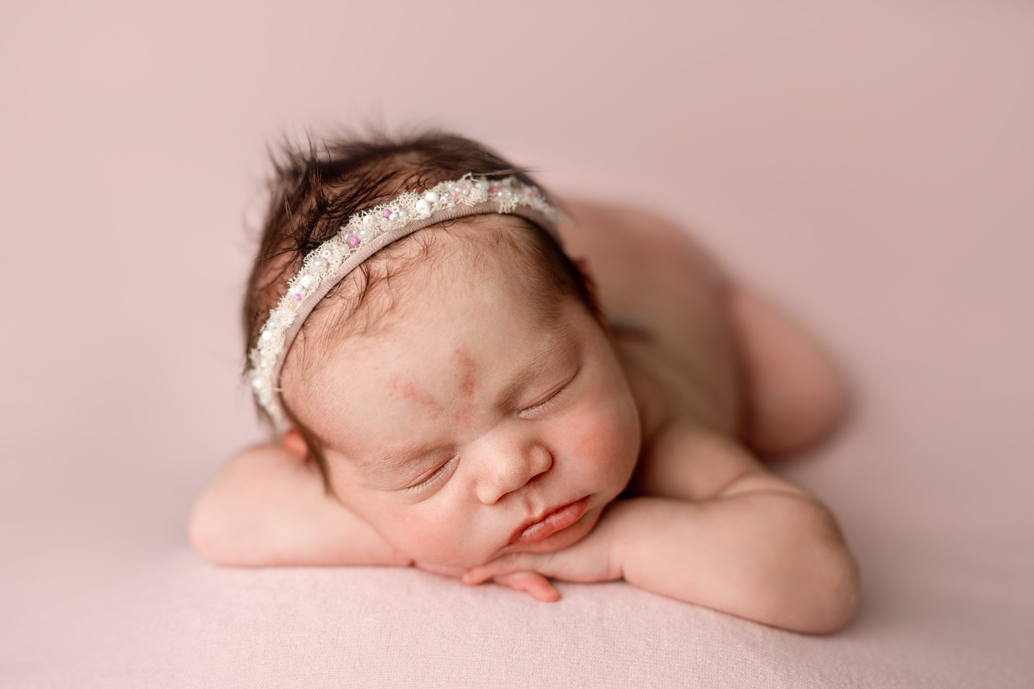 Peaceful newborn baby girl sleeping during a luxury newborn session in Scotch Plains, NJ.