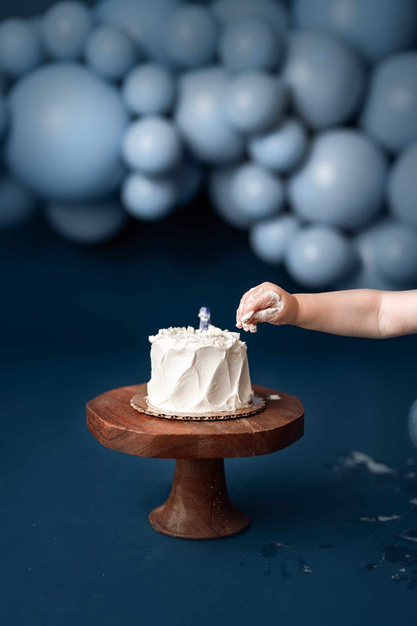 Close up of one-year-old boy's hands in frosting, indoor milestone photography by Scotch Plains NJ photographer.