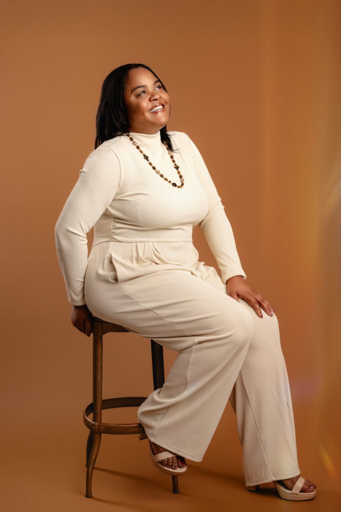 beautiful young black woman poses on a stool at her branding photoshoot in scotch plains nj