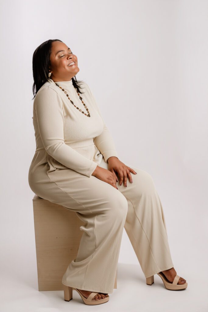 beautiful young black woman poses on a stool at her branding photoshoot in scotch plains nj