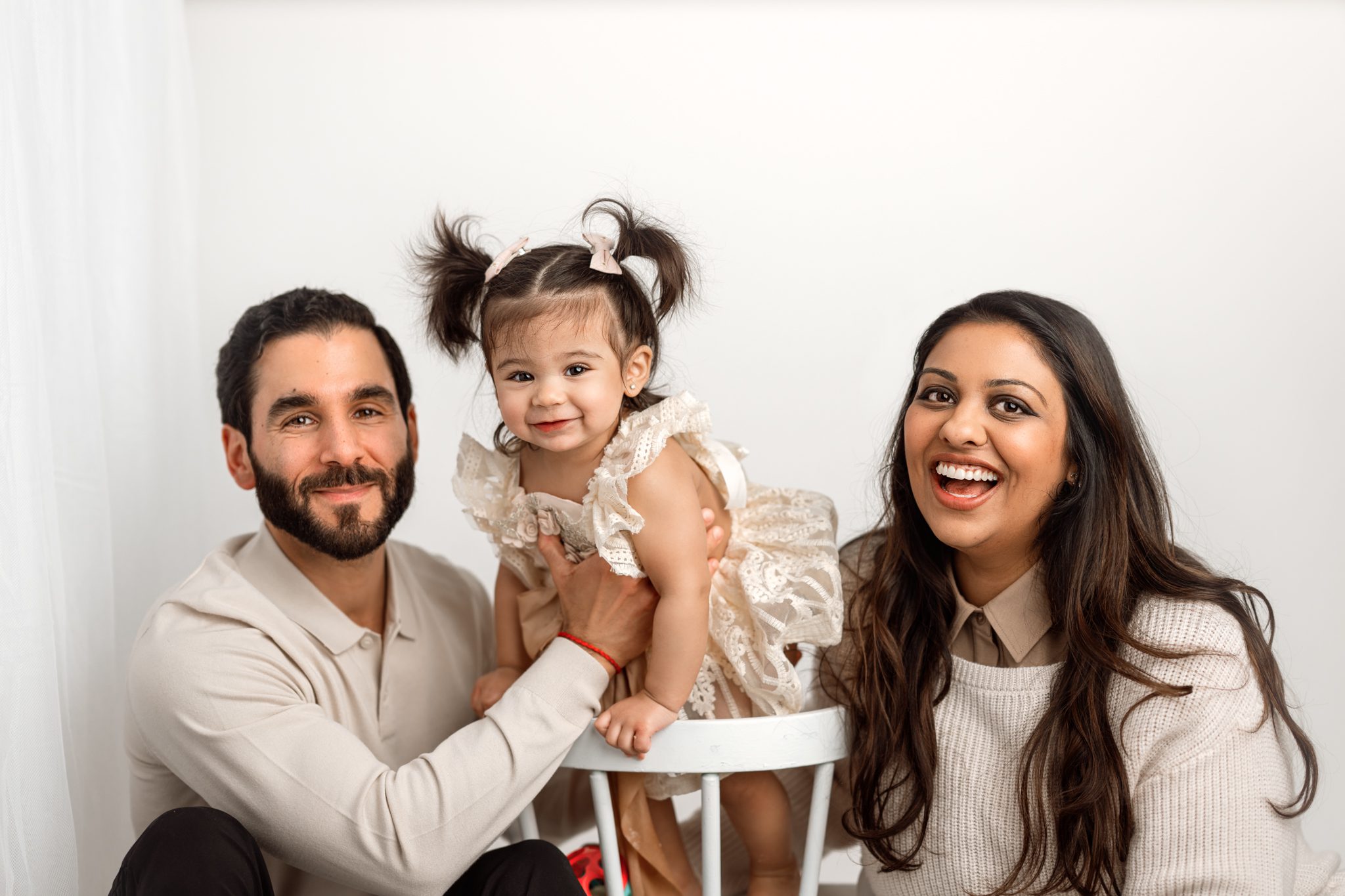 birthday girl poses with her dad and mom