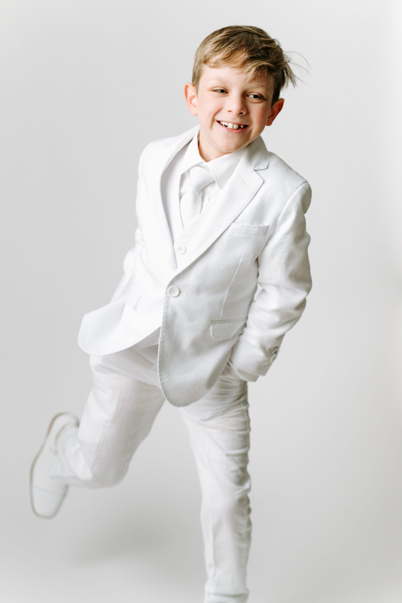 First Holy Communion Portraits of a boy posing in his white suit for his first holy communion in scotch plains nj with joan marie photography