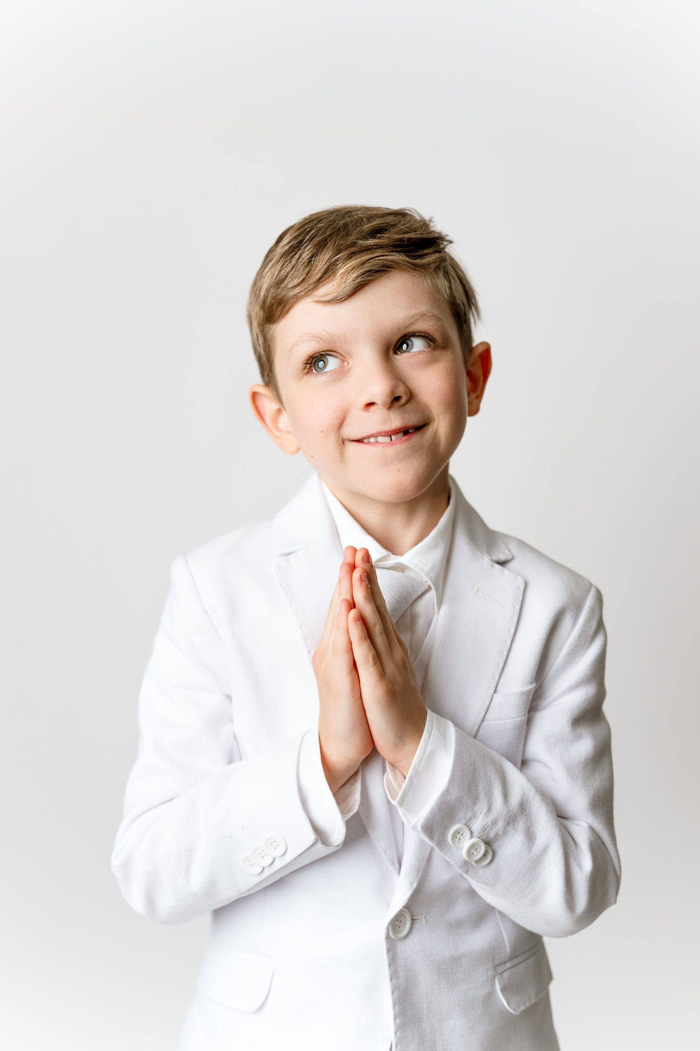 First Holy Communion Portraits of a boy posing in his white suit for his first holy communion in scotch plains nj with joan marie photography