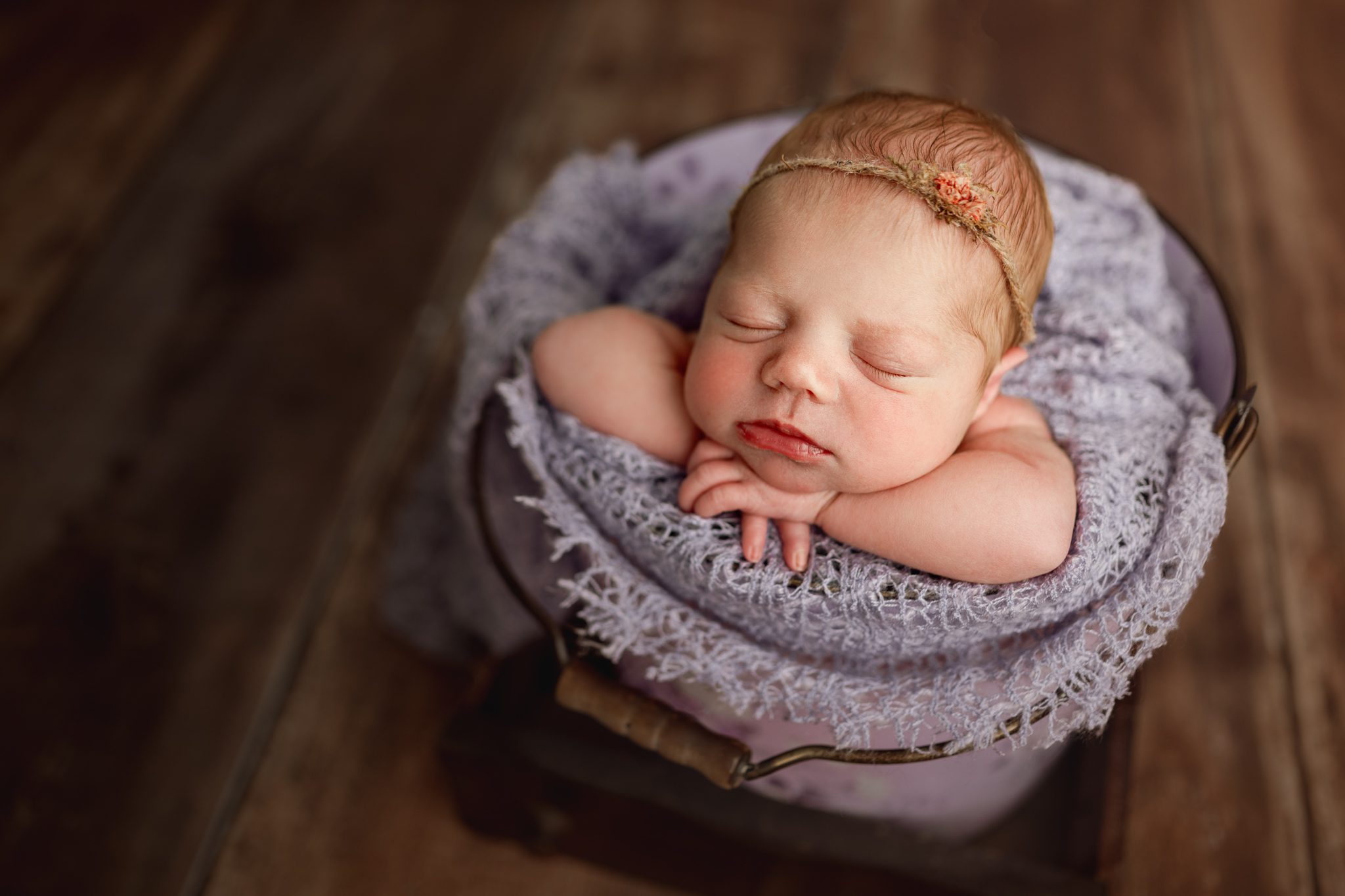 A sweet newborn redhead baby girl sleeping during a customizable newborn photoshoot in Scotch Plains.