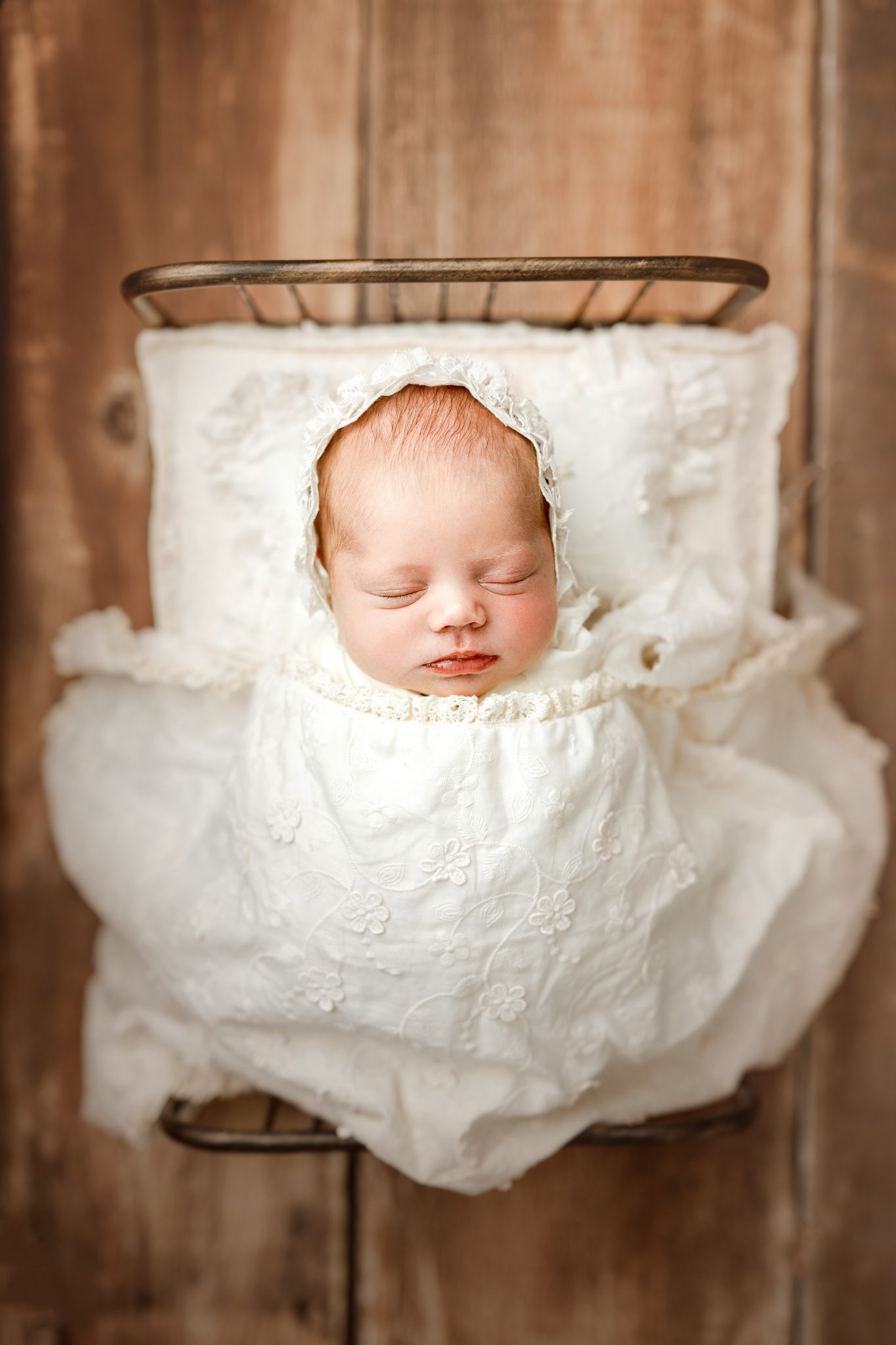 A sweet newborn redhead baby girl sleeping during a customizable newborn photoshoot in Scotch Plains.