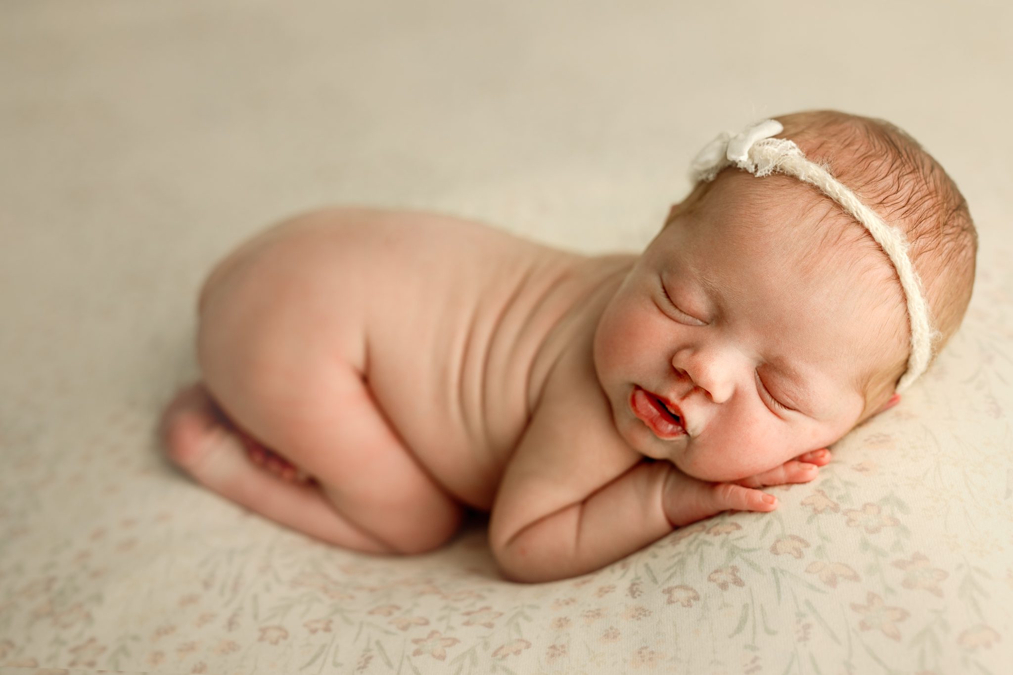 A sweet newborn redhead baby girl sleeping during a customizable newborn photoshoot in Scotch Plains.