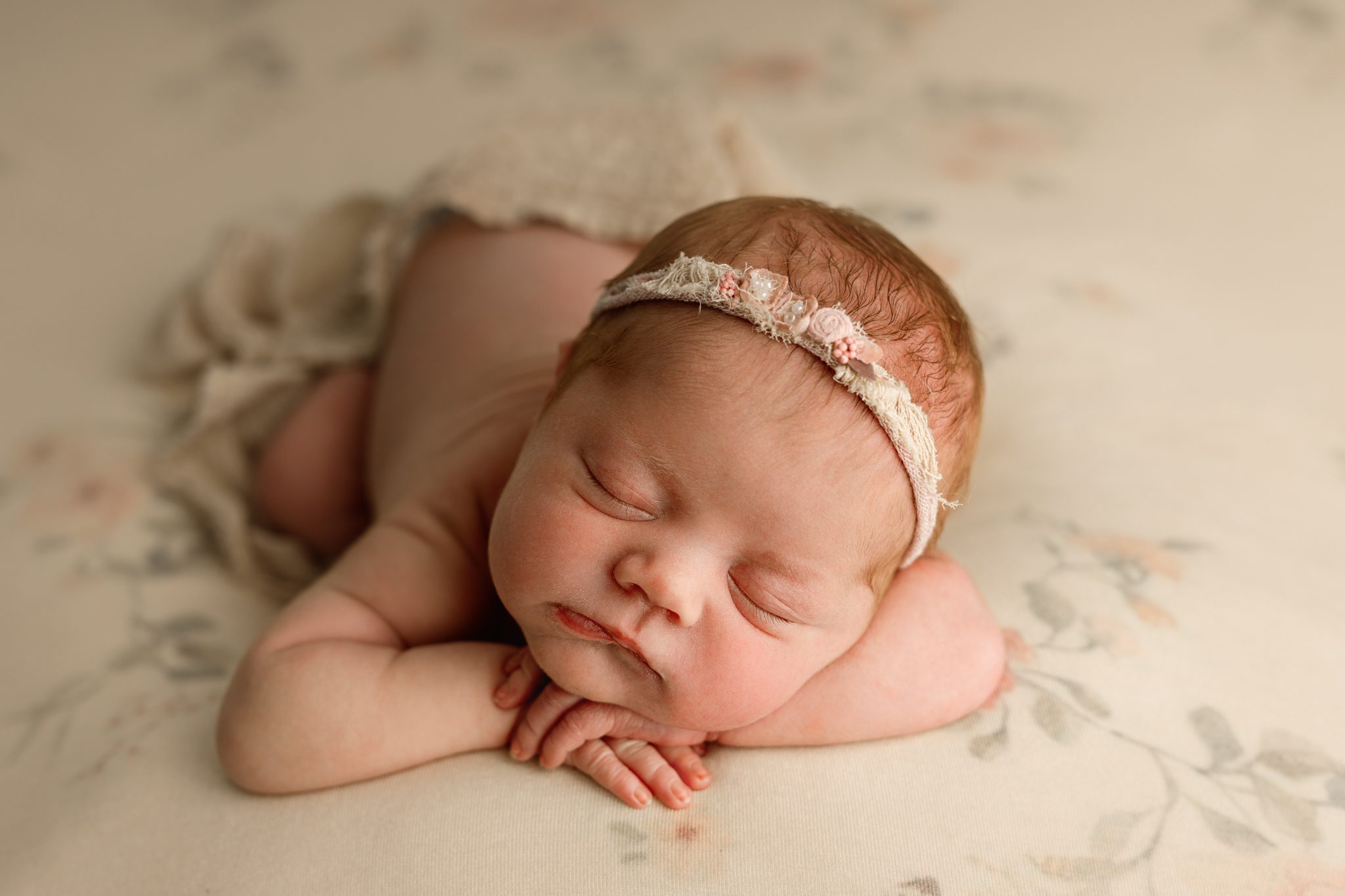 A sweet newborn redhead baby girl sleeping during a customizable newborn photoshoot in Scotch Plains.