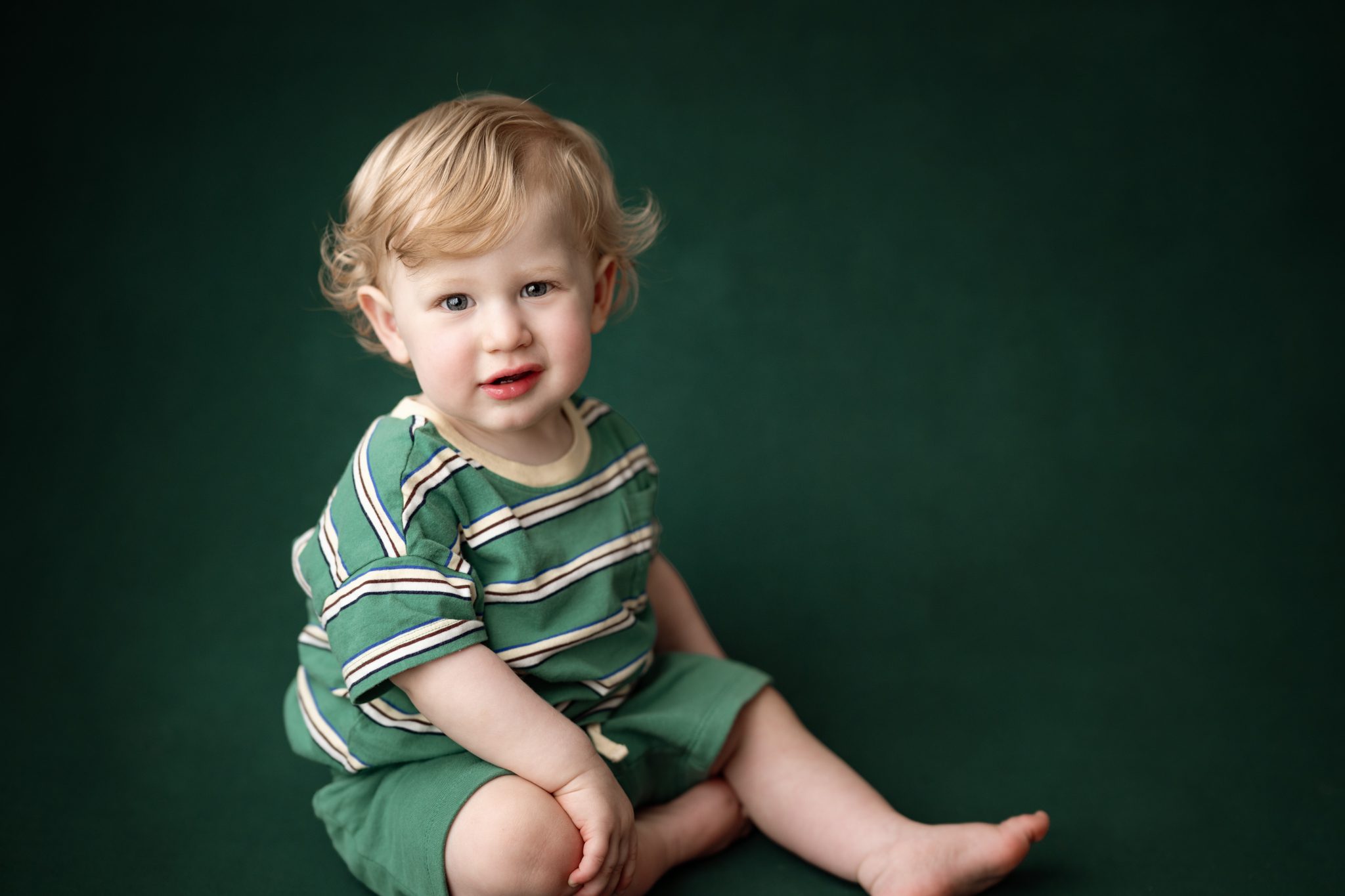A smiling one year old baby boy during a 1st birthday mini portrait session in Scotch Plains