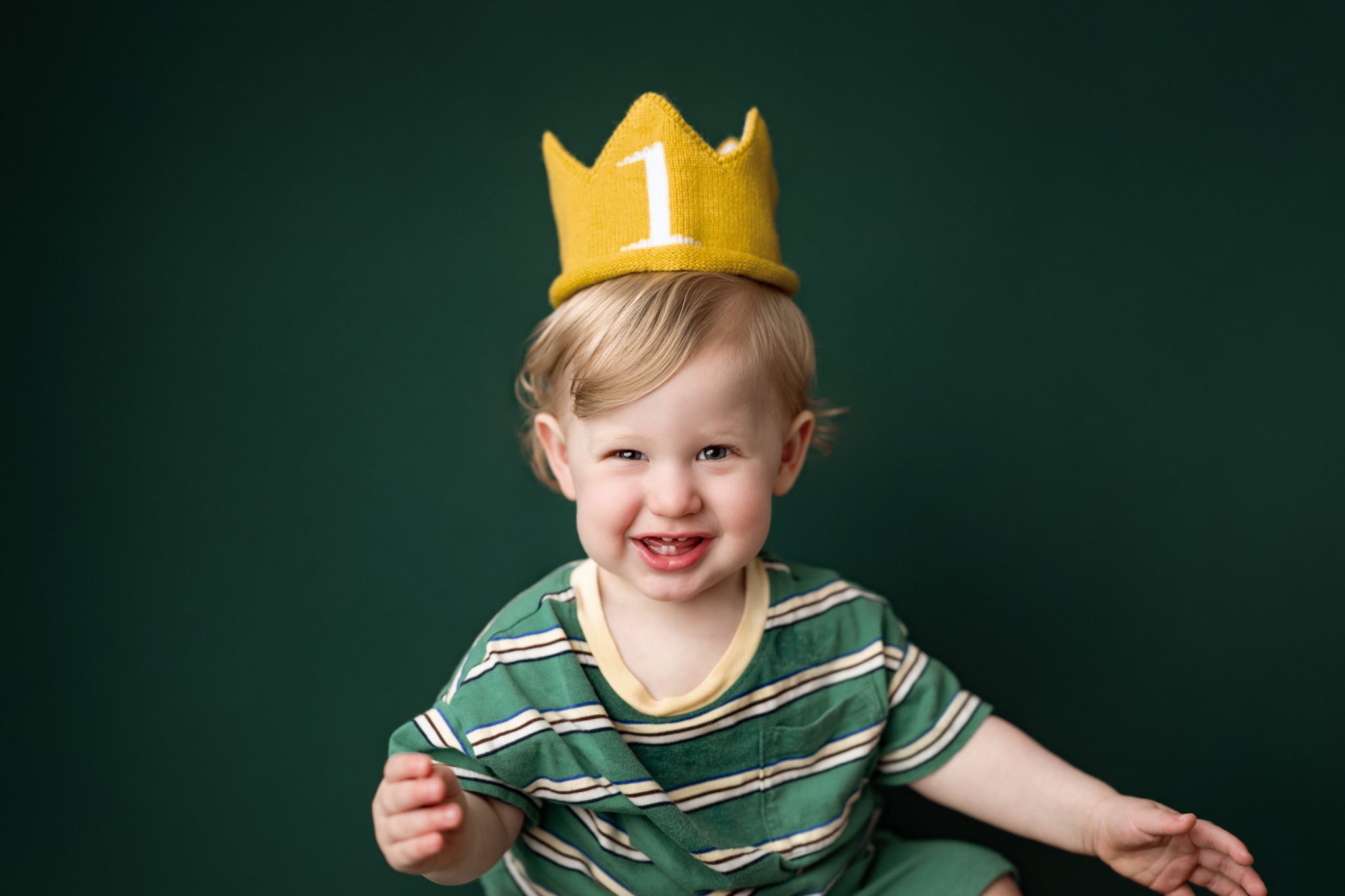 A smiling one year old baby boy during a 1st birthday mini portrait session in Scotch Plains