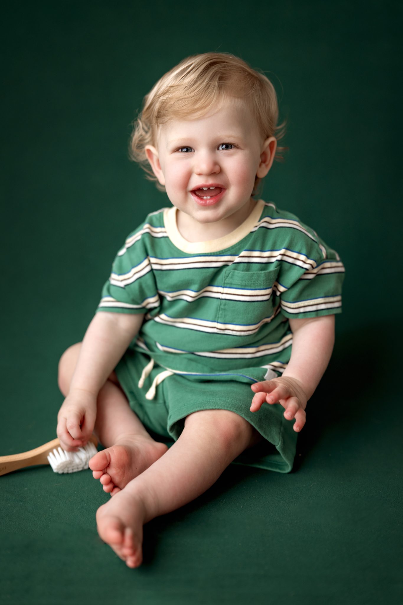A smiling one year old baby boy during a 1st birthday mini portrait session in Scotch Plains