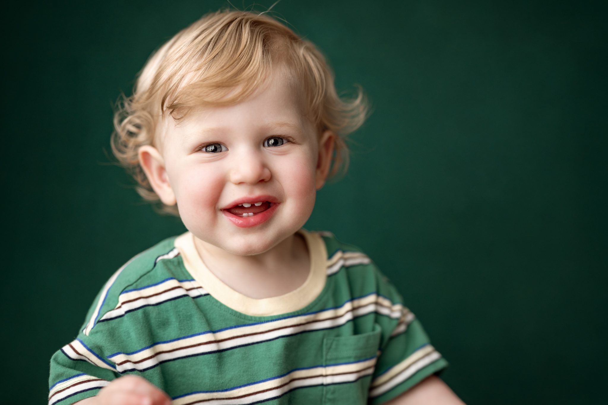 Close up portrait of a one year old boy laughing during her first birthday photoshoot
