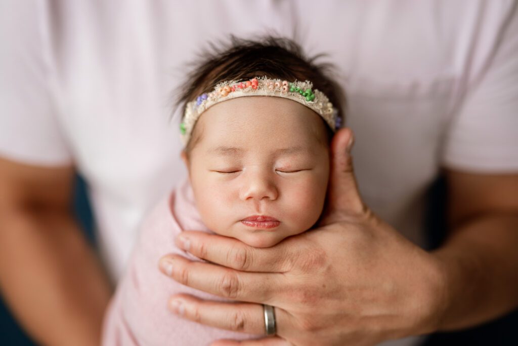 dad holds new baby for the camera